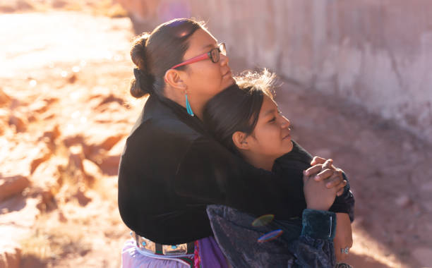 sorelle navajo che si abbracciano sotto la luce del sole - navajo american culture indigenous culture women foto e immagini stock