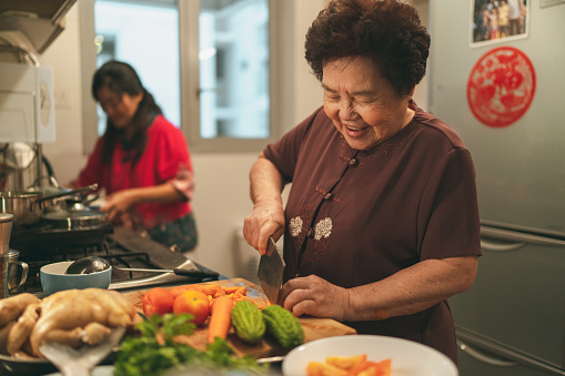 Senior asian woman and her daughter preparing food for their family reunion dinner on Chinese New Year's eve