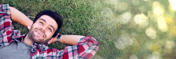 istock The caucasian man was happily lying on the grass with a bokeh copy space. 1288745191