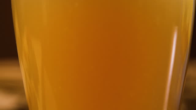 Closeup of Unfiltered Beer Being Poured in Glass