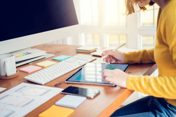 istock Designer woman planning application for mobile phone. UX UI designer concept. 1288746212