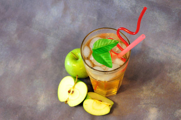 istock Apple juice with ice and fruits on a gray abstract background. 1288747132