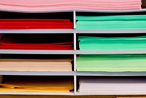 Extreme macro of multicolor background from different colors papers. Abstract colorful vibrant paper textures. Selective focus, shallow depth of field.