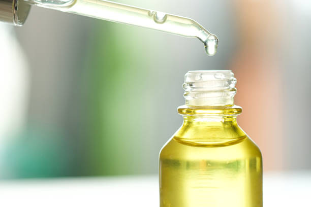 istock Dropping serum collagen moisturizer of face into clear yellow bottle soft light background. Protector skin Treatment facial essence oil, Vitamin C. Beauty and spa Concept. 1288752451