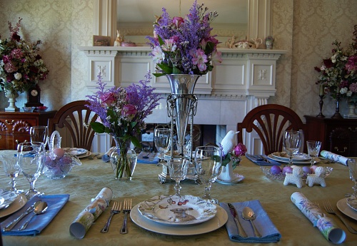 A dining room with flowers and place settings for a spring party.