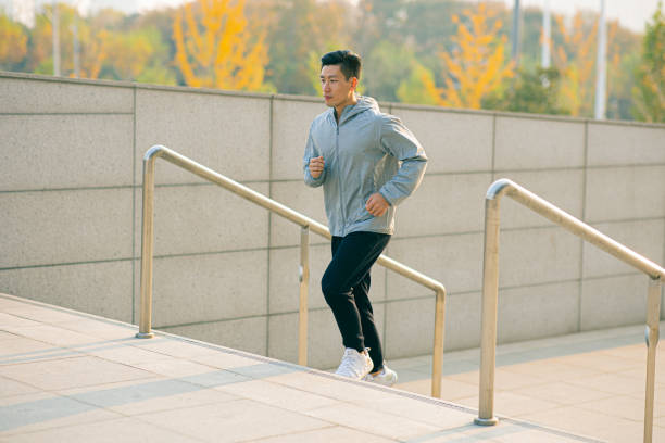 istock Man running up stairs in city 1288755352