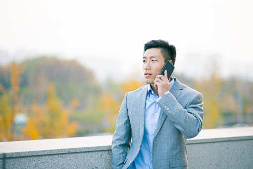 Portrait of young asian businessman talking on the phone