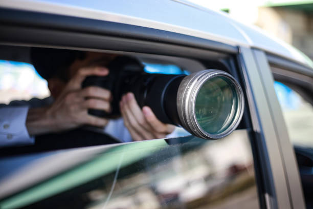 young girl taking photo on camera through mirror of retro minivan