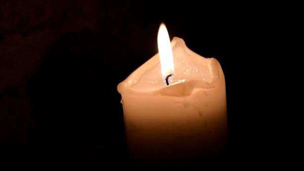 Twinkling candle flame in darkness. Remembrance concept. Day of mourning stock photo