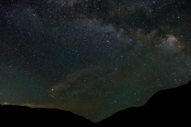 istock Beautiful night sky with many stars and mountain silhouette. 1288761388