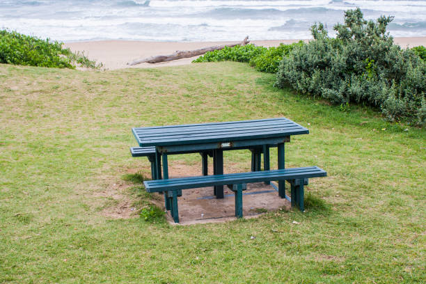 istock Green Picnic Table on a Grassly Slope Overlooking the Sea 1288762822