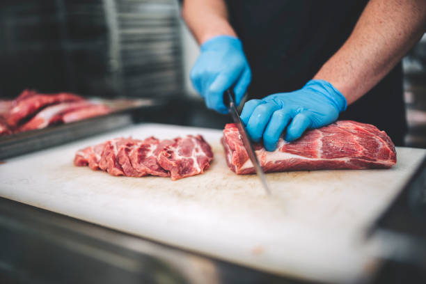 istock Male butcher cut raw meat with sharp knife in restaurants kitchen 1288773075