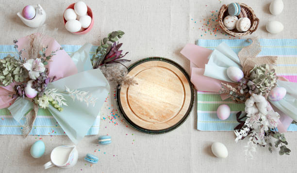 istock Easter dining table setting and decor with a wooden element in the center top view. 1288773651