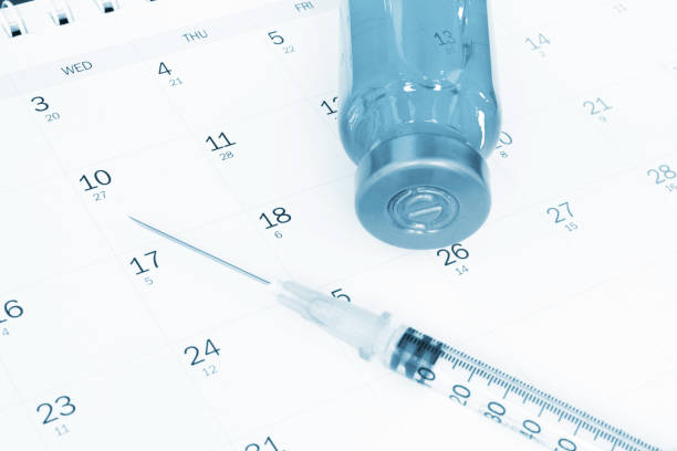 Vaccine and syringe on calendar.