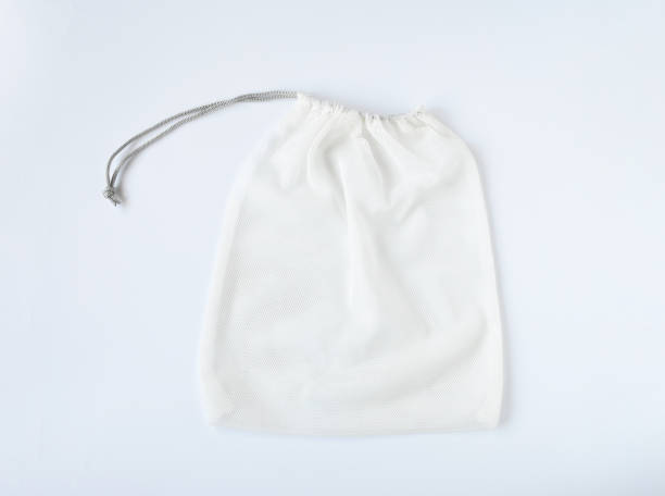 istock Empty mesh shopping bag, white net string on white background. Bag contain vegetable or fruit, reuseable and washable, Eco market bag concept. 1288776737