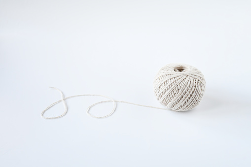 Top view roll of cotton natrue string twine on white background and space for text. Crafting supply, decoration book, or tie a present box.