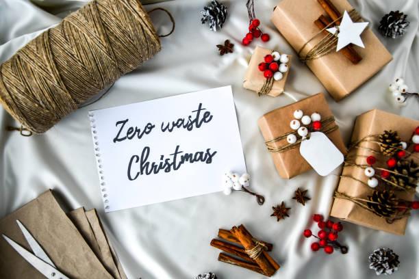 istock Zero waste Christmas text with presents with decorations on champagne colored silk background. Copy space. Eco friendly packed gift with tags from craft cardboard 1288777665