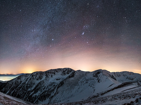Beautiful starry sky over snowy mountains, winter and Christmas time