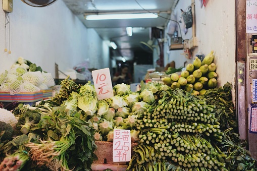 Choy sum, bok choy, broccoli and other green vegetables for sale at the wet markets in Wanchai, Hong Kong - with handwritten signs in Chinese characters