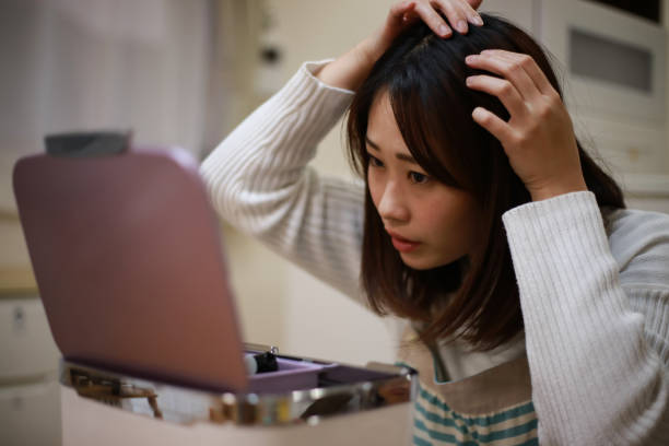 eine frau, die sich um ihre haare kümmert - glatzenbildung stock-fotos und bilder