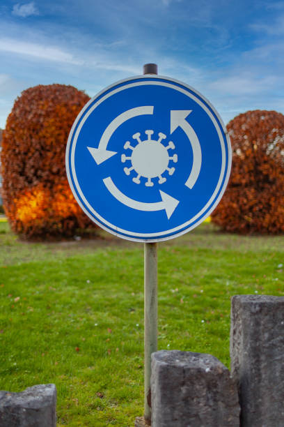 круговой дорожный знак с символом вируса, обозначающий бесконечный круг вирусных инфекций без конца в поле зрения. может применяться к люб� - infinity circle traffic circle sign стоковые фото и изображения