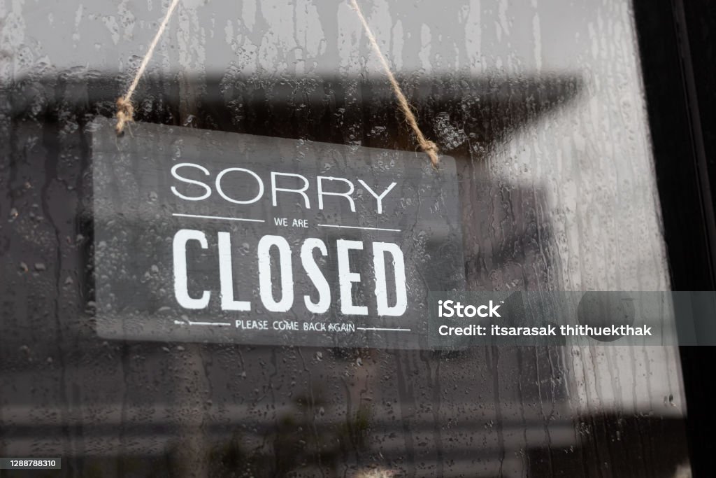 Sorry we're closed sign. grunge image hanging  on a rainy day. Closed Sign Stock Photo