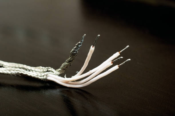 istock Metal shielded wire on black background close up, macro photo 1288788312