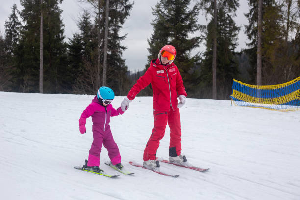 The child learns to ski with the instructor.