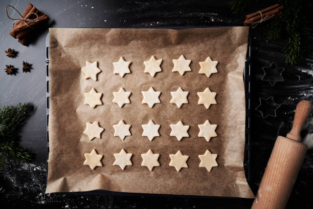 вид на противень с сырым печеньем в форме звезды - baking paper cookie tray стоковые фото и изображения