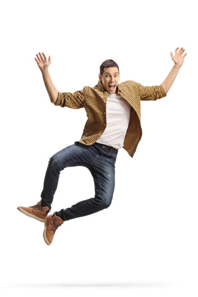 istock Excited young man in shirt and jeans jumping 1288791307