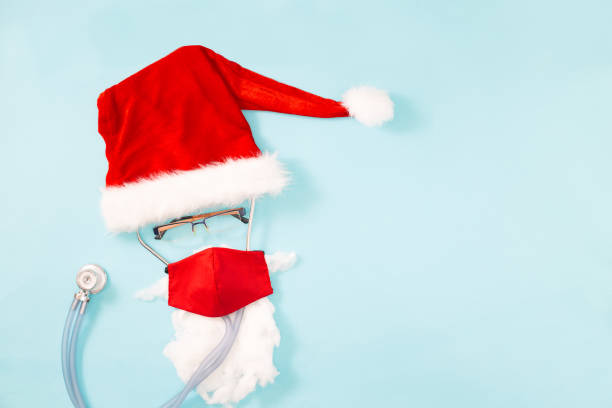 istock Abstract Christmas doctor card with stethoscope and red protective mask on blue background.Concept christmas , new year covid-19. Coronavirus 2020 1288792603