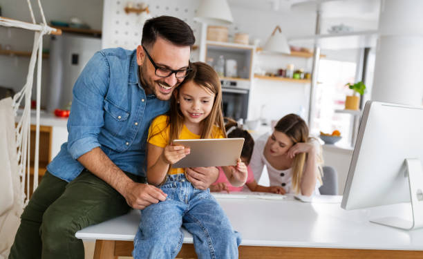 istock Happy family spending time at home and using digital, technology devices. 1288793388