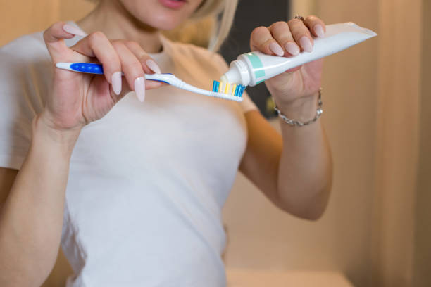 istock Girl applied toothpaste to brush in the bathroom. 1288793565