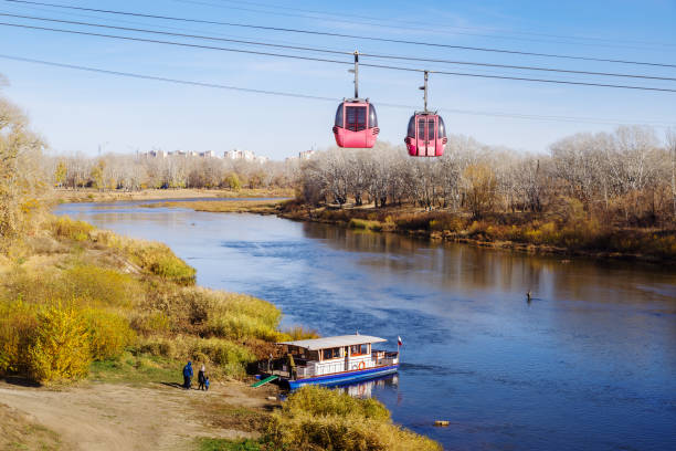 Cable car and pleasure boat near the river bank stock photo