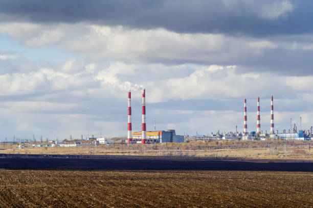Autumn landscape with a plowed field, CHP and gas processing plant on the horizon