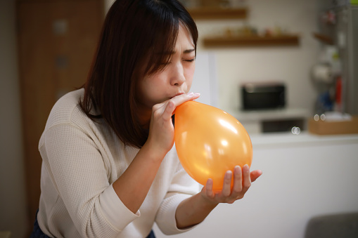 Woman inflating balloons