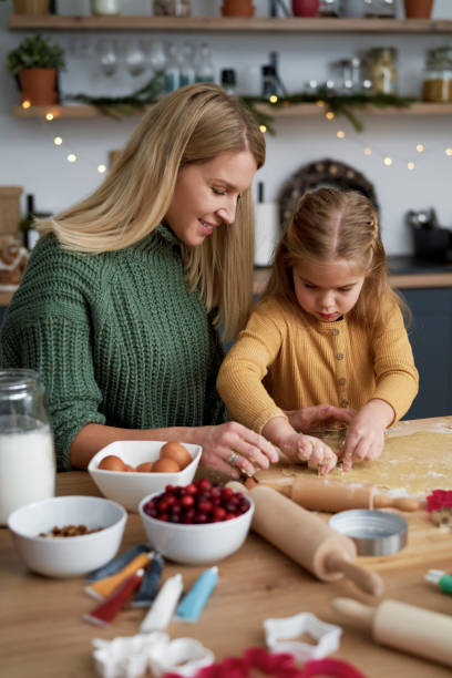 mom and daughter making christmas cookies together - pastry cutter family holiday child imagens e fotografias de stock