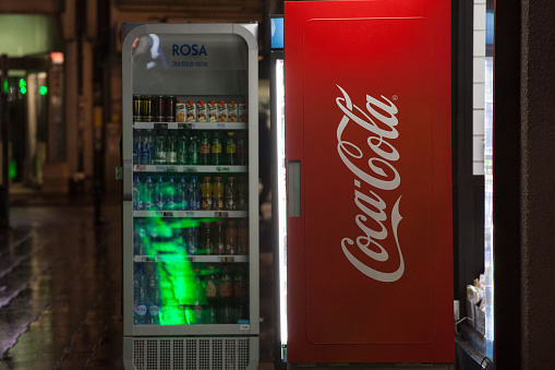 Picture of a red fridge with the coca cola logo taken on the shelves of a fridge in Belgrade, Serbia. Also known as Coke, it is a carbonated soft drink manufactured by The Coca-Cola Company