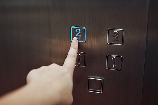 Cropped shot of a woman pressing a button in an elevator