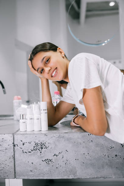 painting of a woman with cosmetic bottles in the bathroom stock photo