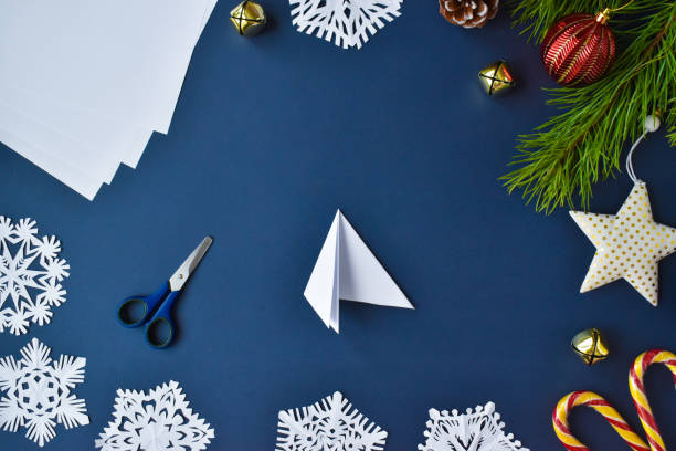 istock Step-by-step instructions. The snowflake is made of paper. Step 5 bend the sheet from the left. Flat lay.Top view 1288804178