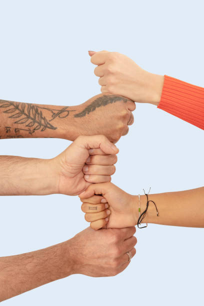 istock Cropped image of friends stacking fists against white background 1288804439