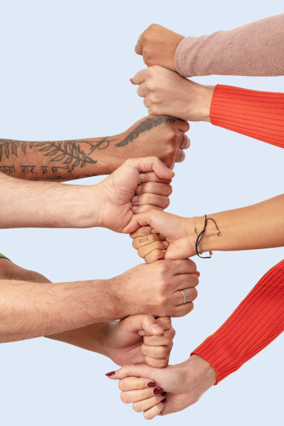 istock Cropped image of friends stacking hands against white background 1288804445