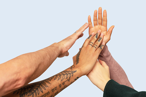 Cropped image of friends giving high-five against white background