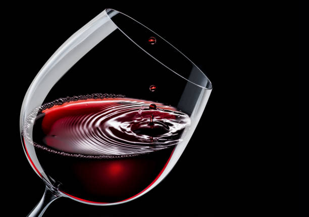 красное вино наливают в бокал на черном фоне. - wine decanter red restaurant стоковые фото и изображения