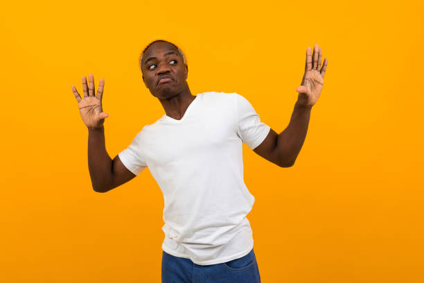 istock thinking african black man in a white t-shirt with a layout posing dancing on a yellow background 1288805551