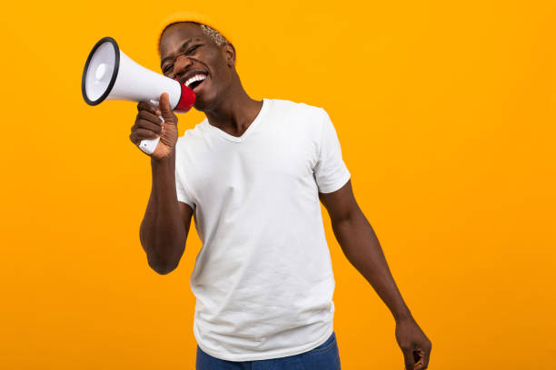 istock black african man singing in a megaphone on isolated orange background 1288805565