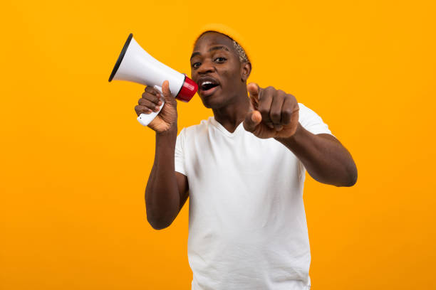 istock black african man speaks in megaphone on isolated yellow background 1288805574