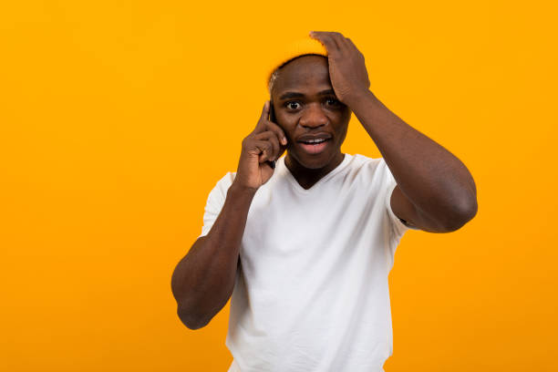 istock handsome black man holding his head and talking on the phone 1288805881