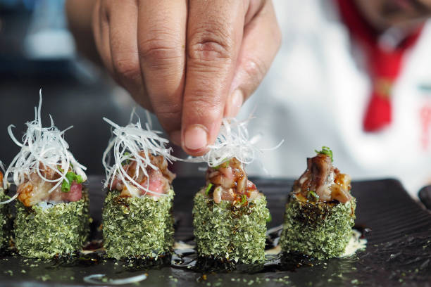 японский суши рулон увенчанный нарезанным аками или тунцом подается с васаби и маринованным имбирем. - tuna prepared fish mayonnaise restaurant стоковые фото и изображения